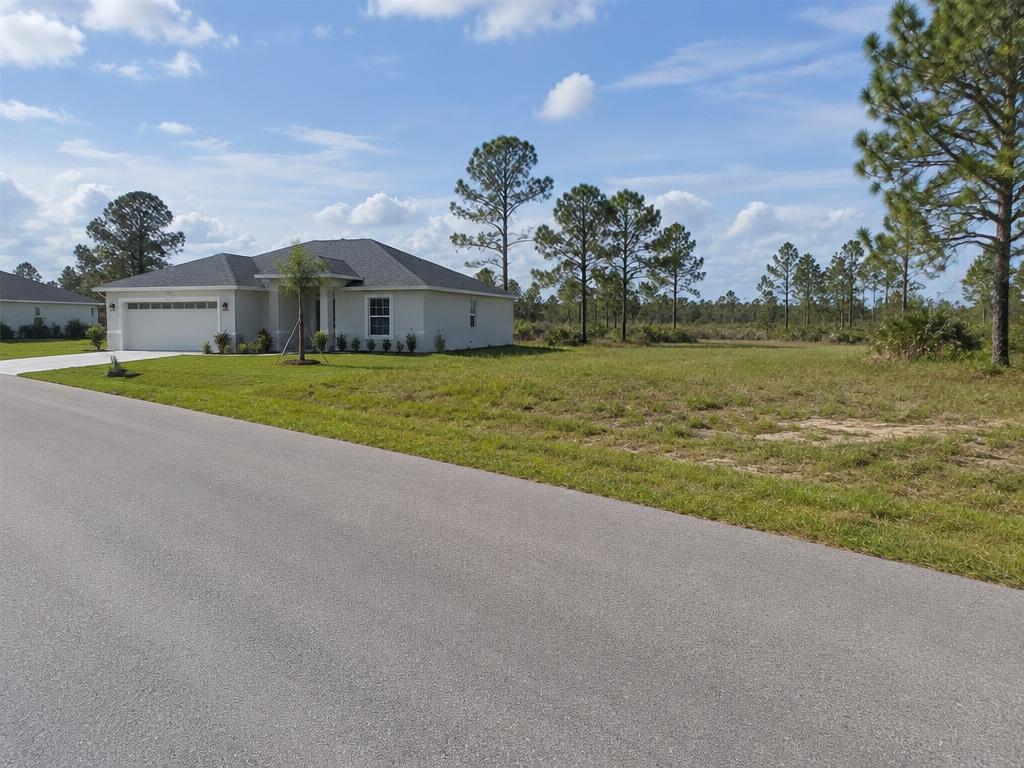 New single-family home beside a vacant lot in Lehigh Acres